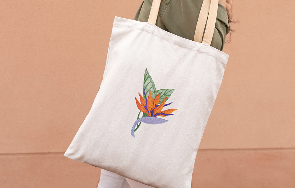 Natural-colored fabric featuring a meticulously embroidered Birds of Paradise Australian native flower.